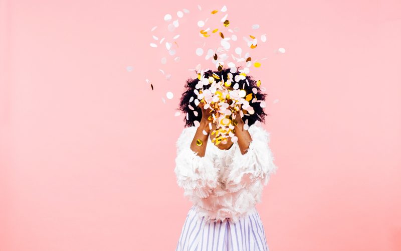 Confetti throw- celebrate  success, isolated on pink