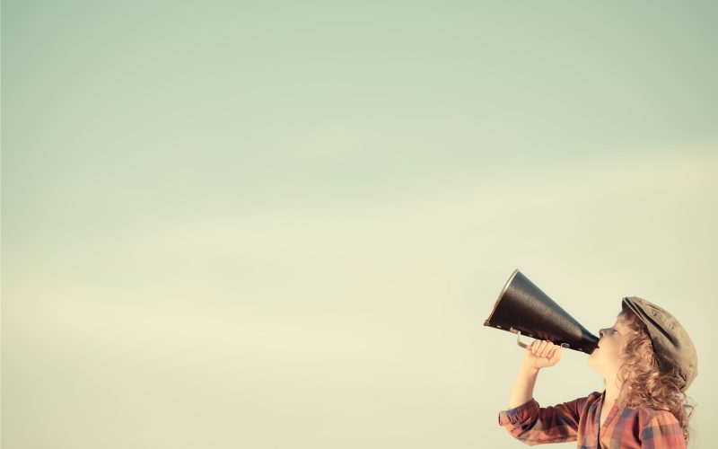 Kid shouting through vintage megaphone. Communication concept. Retro style